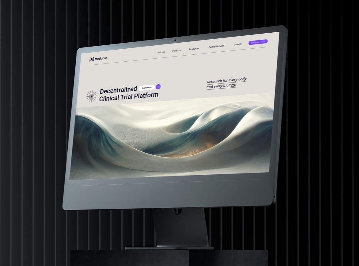 Medable website shown on a desktop display with flowing abstract form and Decentralized Clinical Trial Platform headline