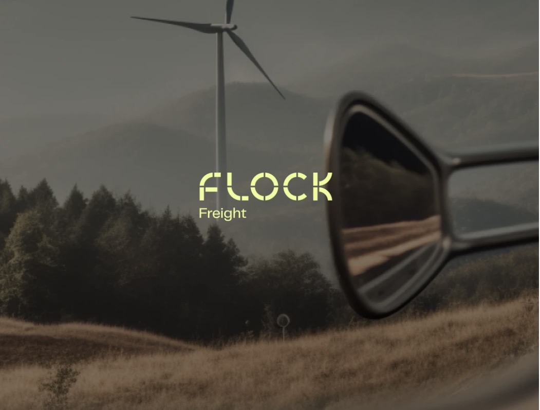 Flock Freight wordmark over a scenic road and wind turbine